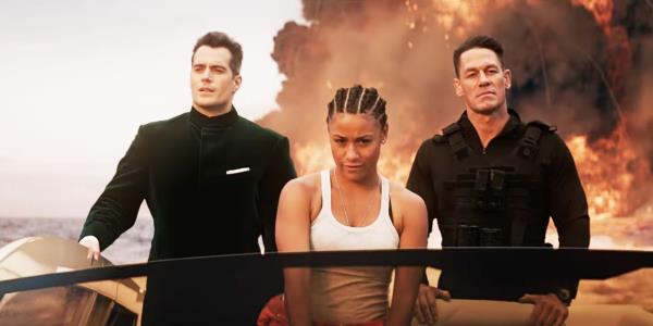 Henry Cavill, Ariana DeBose, and John Cena on a boat with an explosion behind them in Argylle.